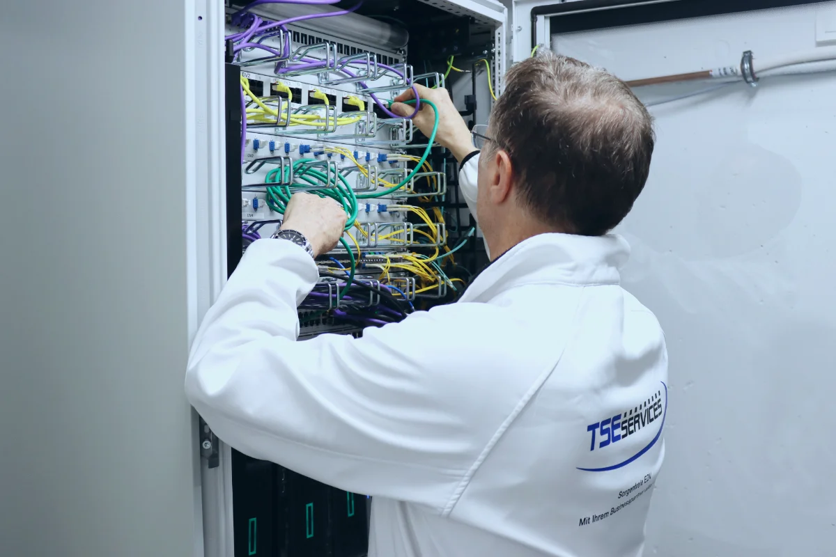 Thomas Spreitzer von TSE Services arbeitet an einem offenen Serverschrank.